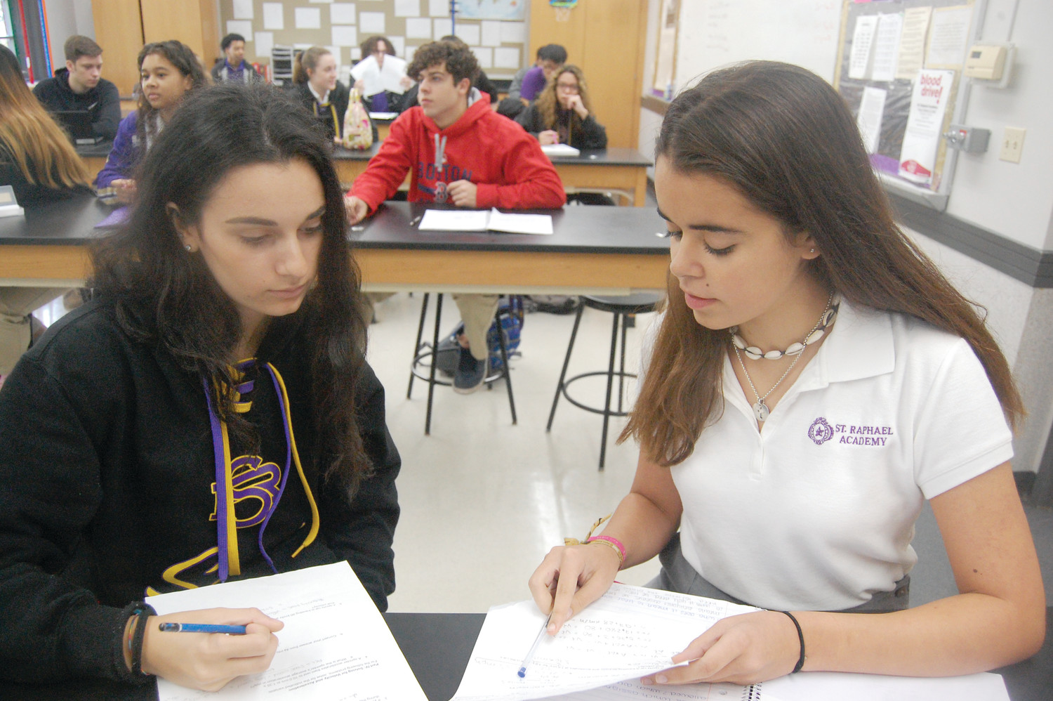 Silvia Sternaiuolo, 16, of Italy, left, and Teresa Rebelo, 15, of Portugal in a physics class at St. Raphael Academy. A new program that began this year allows high school-aged girls from around the world to stay at Overbrook Academy and attend classes by day at St. Raphael Academy.